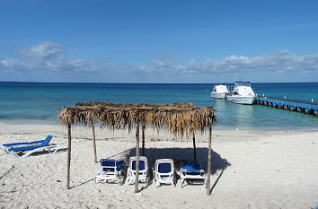 Strand mit Steg und Booten in der Karibik