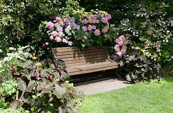 Bank zwischen Blumen im Park