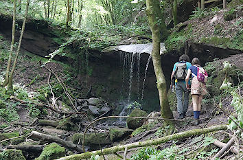 Wanderer an einem Wasserfall des Butzerbachs