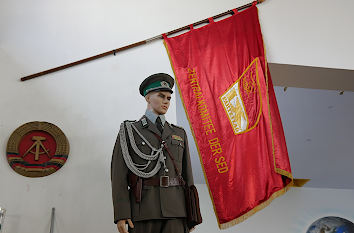 DDR-Polizist vor SED-Parteitagsflagge