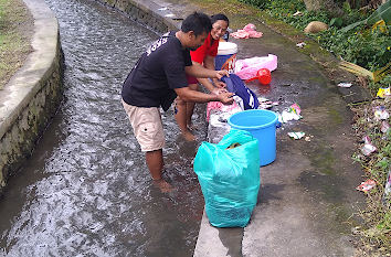 Wäsche wird auf Bali im Kanal gewaschen